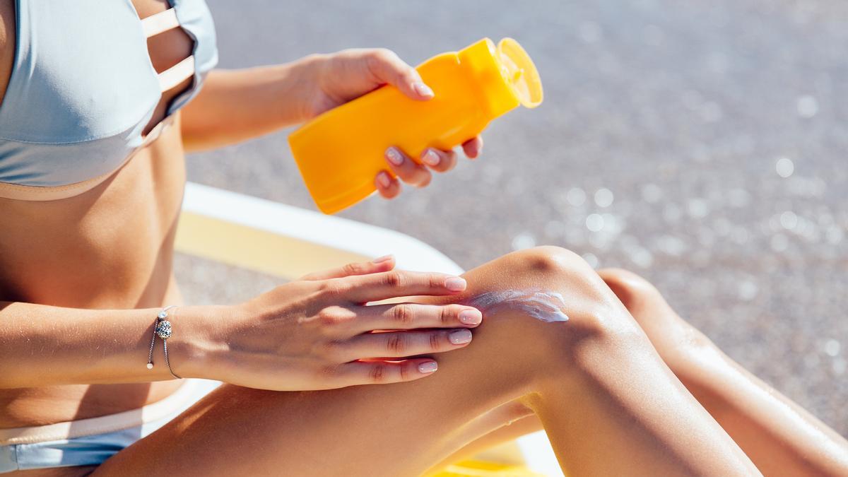 Una persona se echa crema solar.