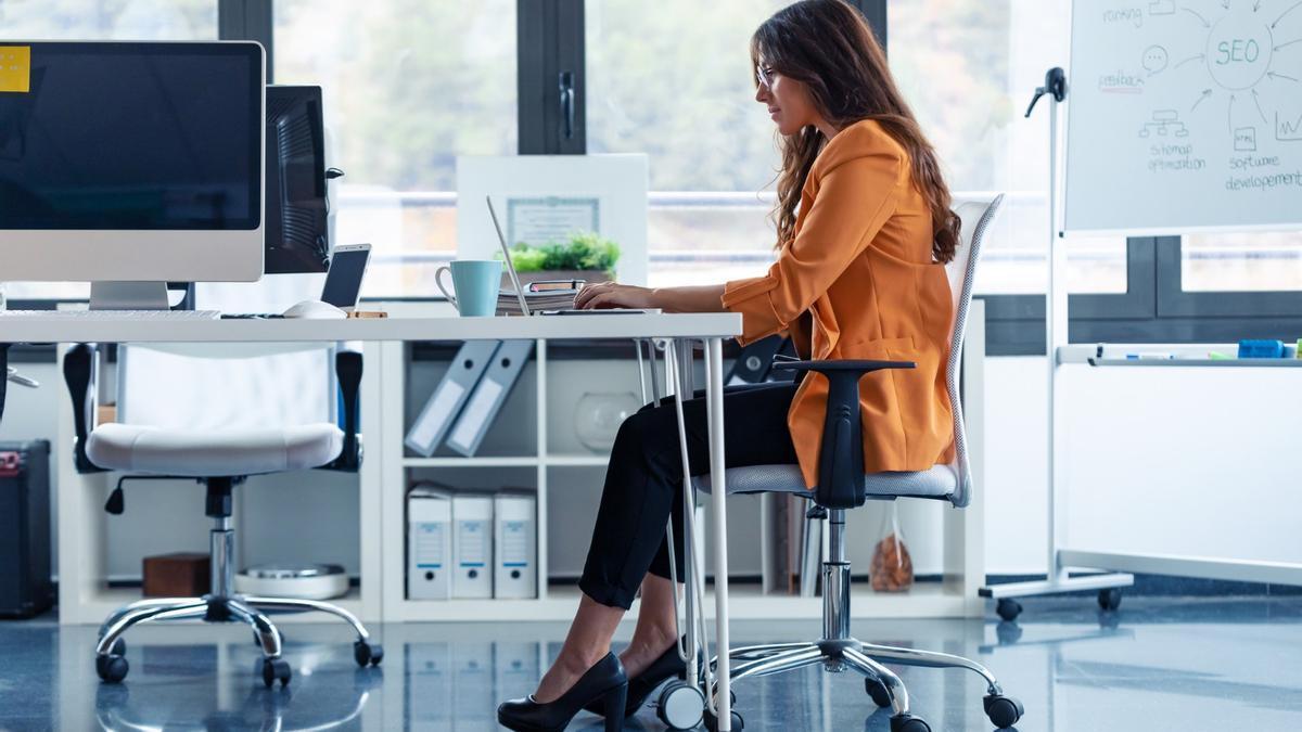 Una mujer, trabajando sentada en una oficina.