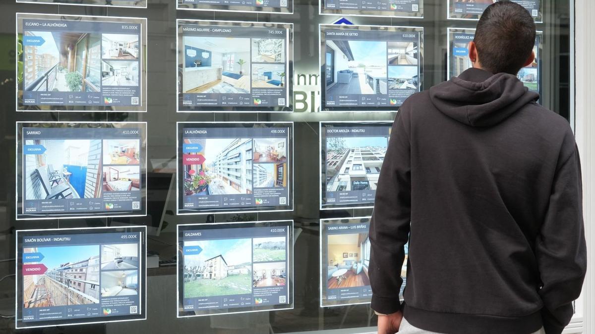 Un joven contempla las ofertas en una inmobiliaria de Bilbao.