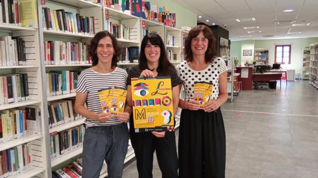 Trabajadoras de la biblioteca municipal muestran la programación del nuevo curso.