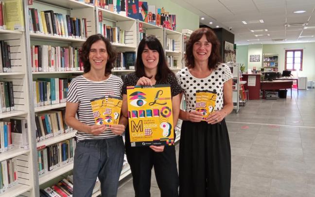Trabajadoras de la biblioteca municipal muestran la programación del nuevo curso.