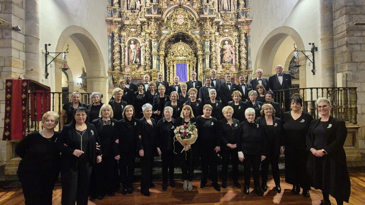 Marian Lasa, con un ramo de flores, rodeada por sus compañeros de Santikutz.