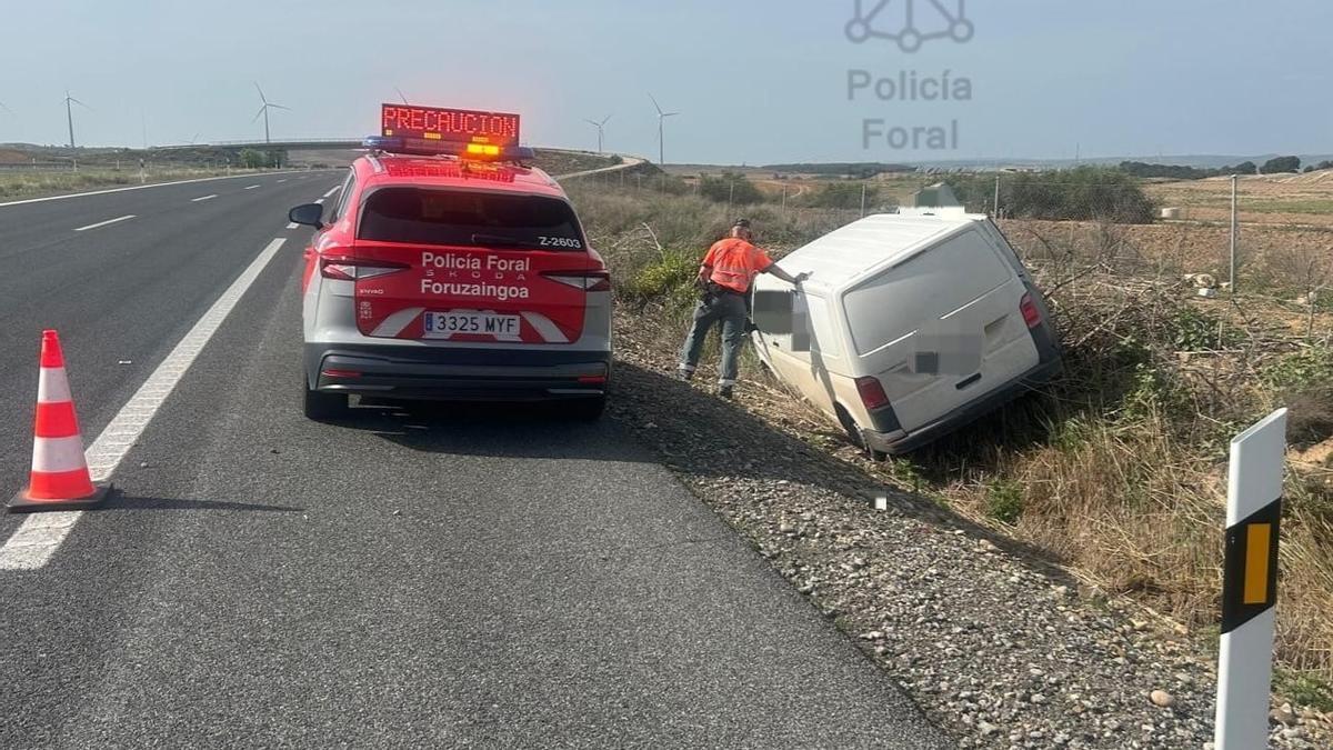 Un policía foral examina el vehículo accidentado. Cedida