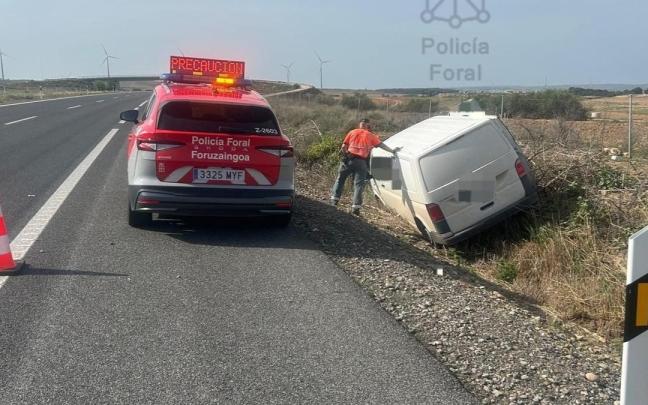 Un policía foral examina el vehículo accidentado. Cedida
