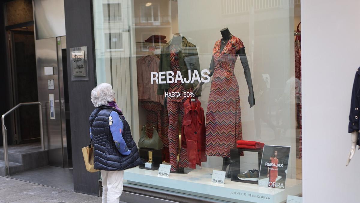 Una mujer observa un escaparate durante unas rebajas.