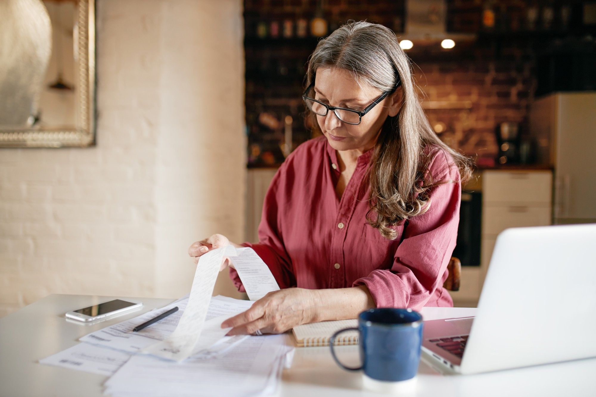 Una mujer incorpora facturas a la contabilidad doméstica.