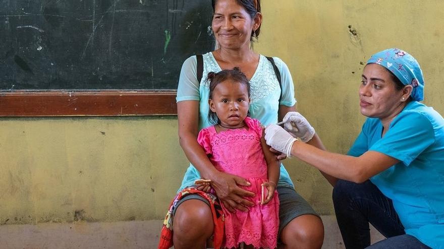Una niña recibe una vacuna en Perú.