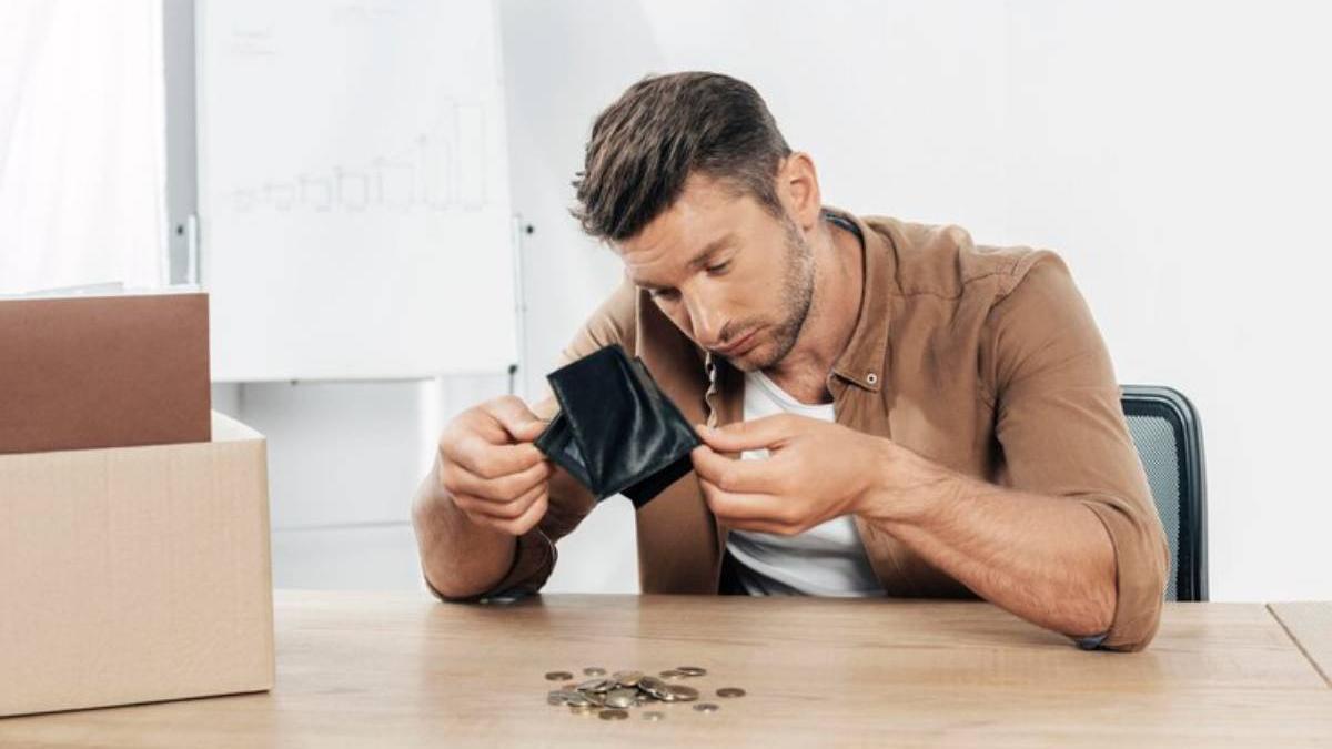 Hombre comprobando el dinero que lleva en la cartera