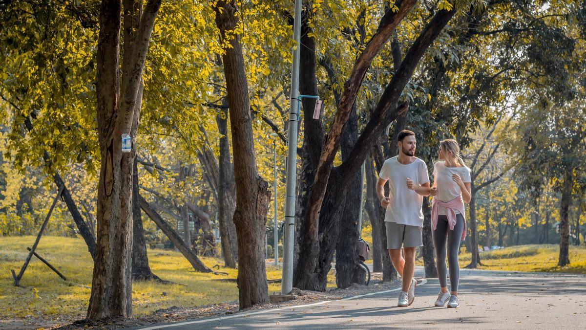 Un hombre y una mujer caminan por un parque.