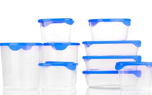 Tuppers apilados en una estantería.