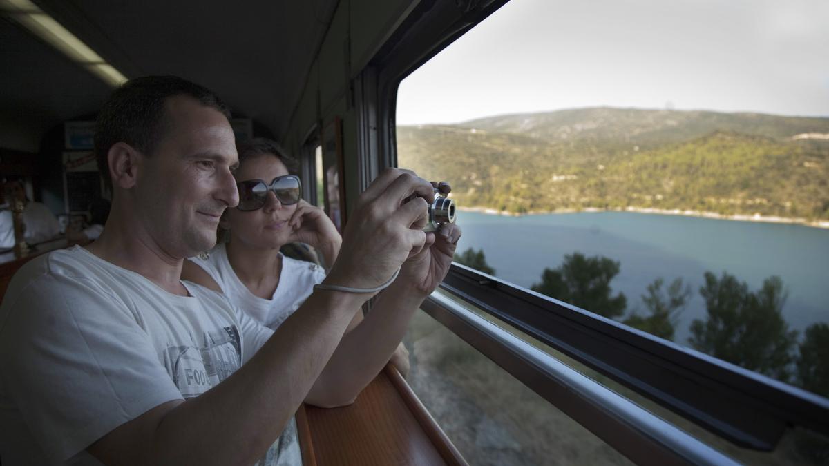 Viajeros tomando fotografías desde el interior del vagón.