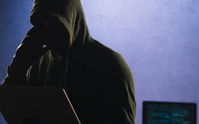 Un ciberdelincuente con un ordenador portátil.