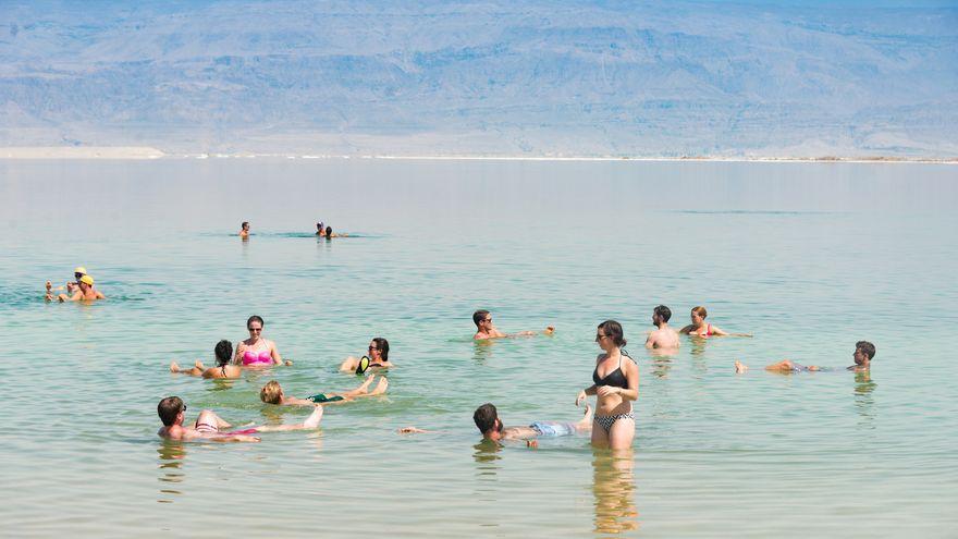 Varios turistas comprobando lo fácil que se flota en el Mar Muerto.