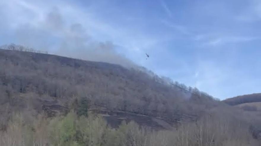 Un helicóptero descarga agua sobre el incendio.