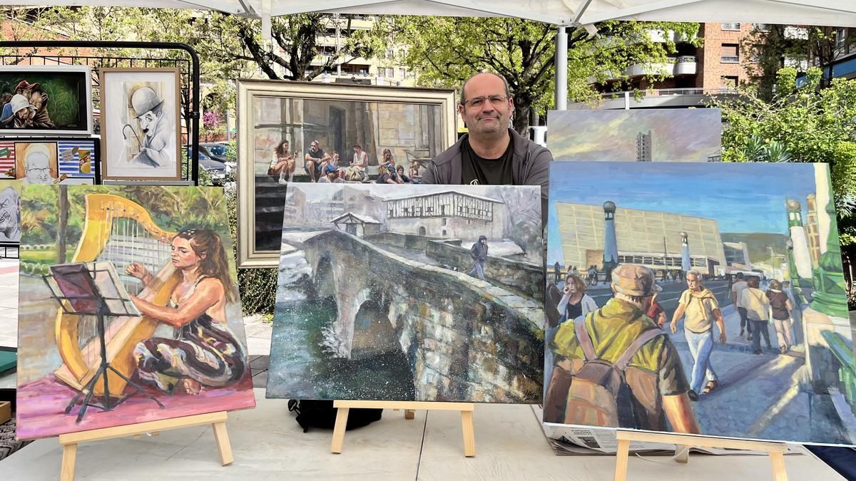 El artista beasaindarra Iker Dorronsoro junto a sus pinturas en el II. Arte Eguna.