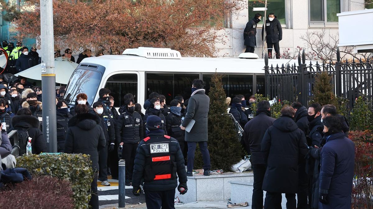 Un minibús sale de la residencia presidencial de Corea del Sur durante la ejecución de la orden de arresto contra Yoon Suk Yeol.