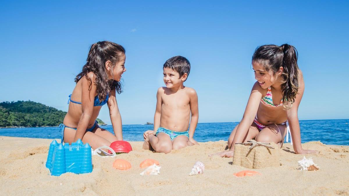Un grupo de niños se divierte en la playa en pleno verano
