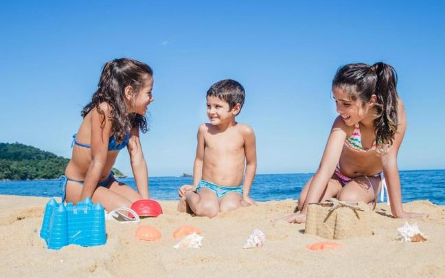 Un grupo de niños se divierte en la playa en pleno verano