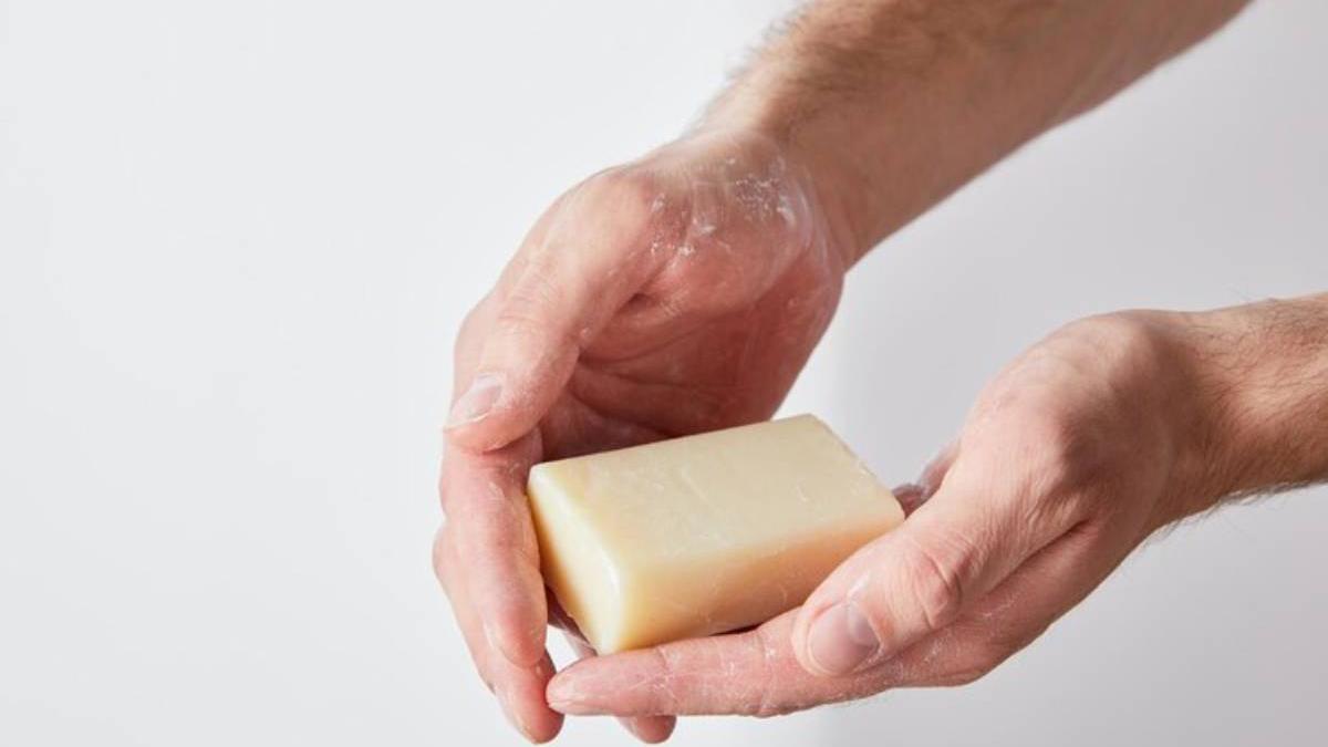 Manos de un hombre sostienen una pastilla de jabón