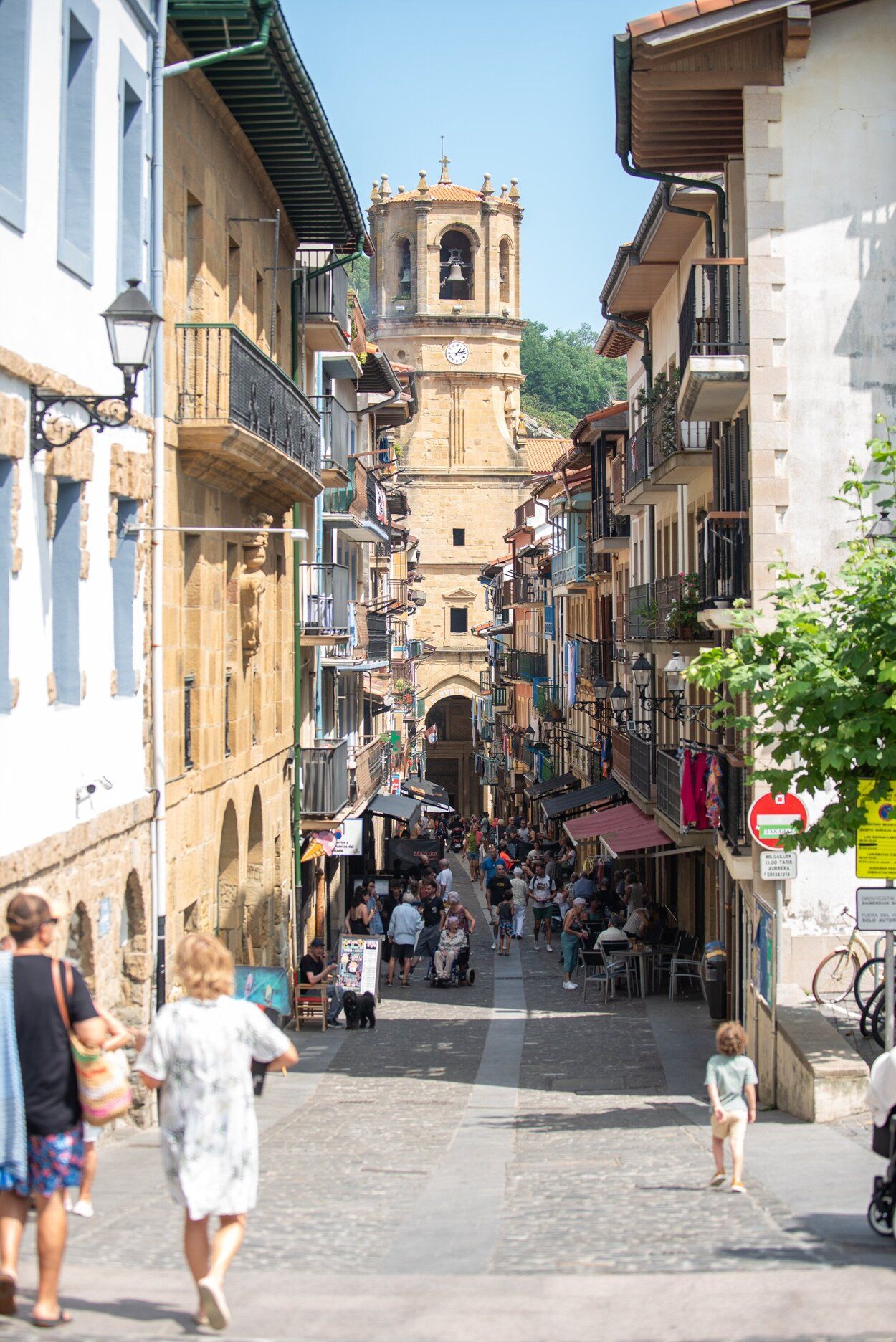 Personas caminando con la Iglesia de San Salvador al fondo.
