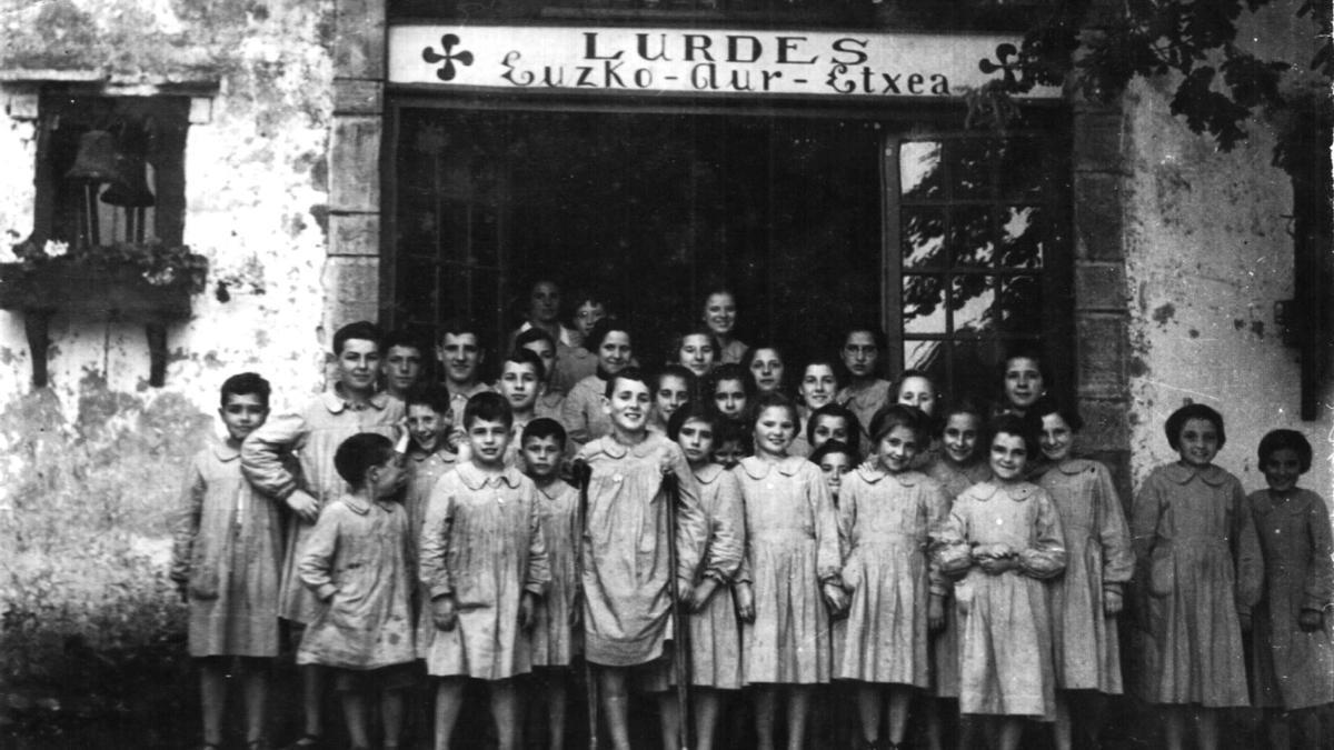 Los 34 niños y niñas de la colonia Lurdes Aur-Etxea frente a la puerta de entrada de Denisenia