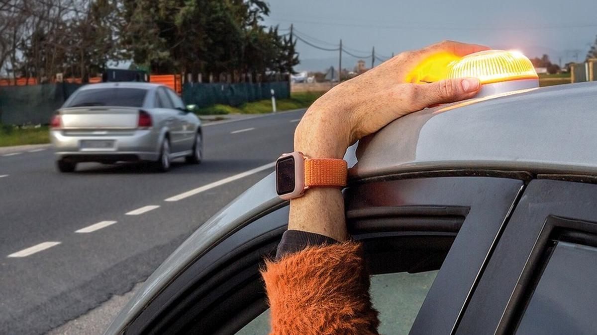 Una persona coloca una baliza V16 en el techo de su coche.