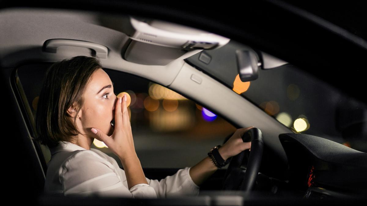 Una mujer, asustada mientras conduce de noche.