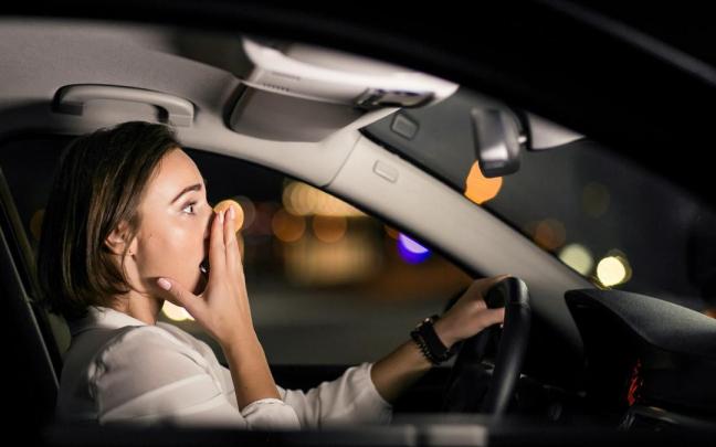 Una mujer, asustada mientras conduce de noche.