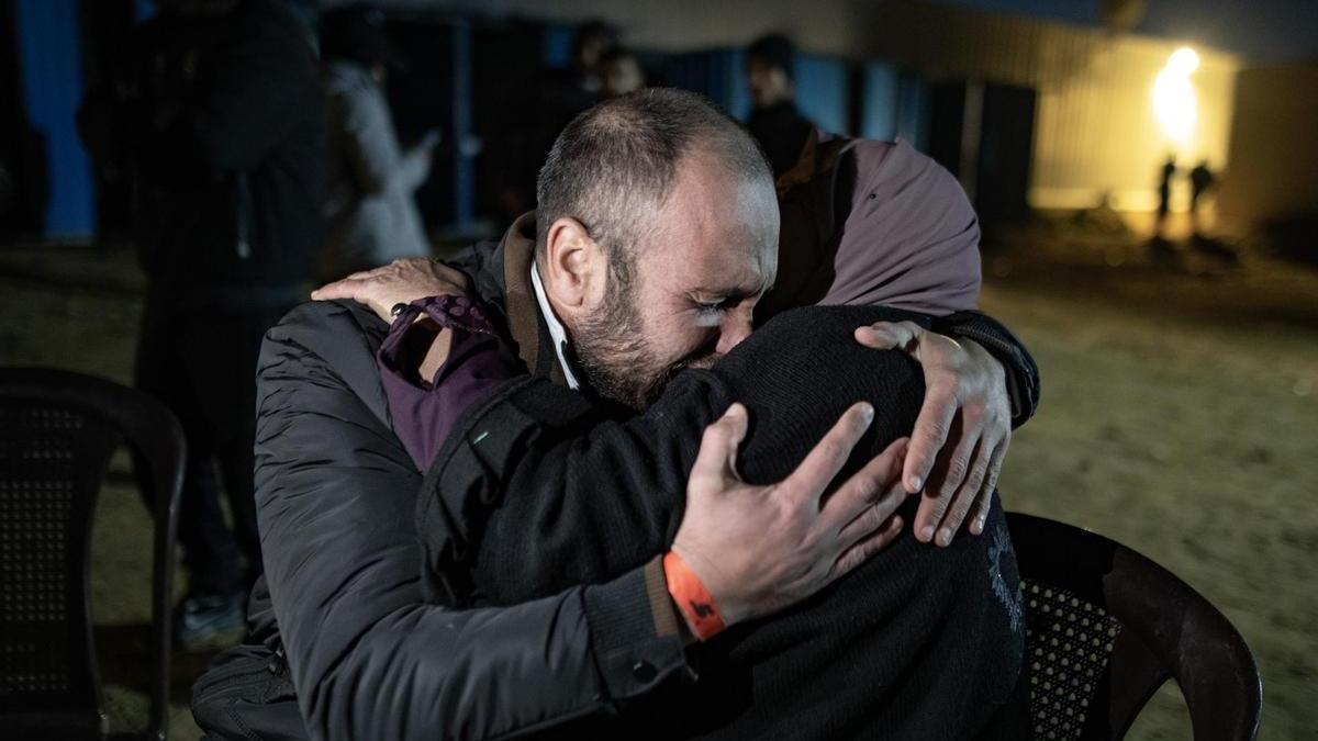 Una mujer se abraza a uno de los más de 600 presos palestinos liberados este jueves.