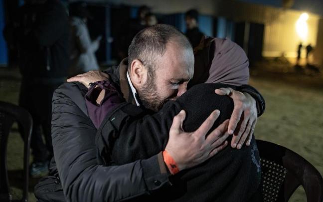 Una mujer se abraza a uno de los más de 600 presos palestinos liberados este jueves.