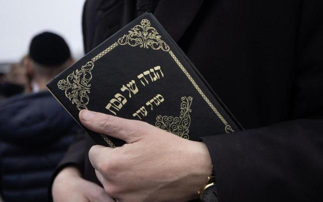 Un hombre sujetando una Torá en una imagen de archivo.