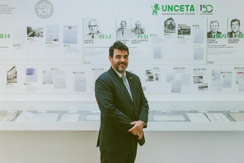 Pablo Garate posa junto a un mural en el que se repasan los 150 años de historia del grupo Unceta.
