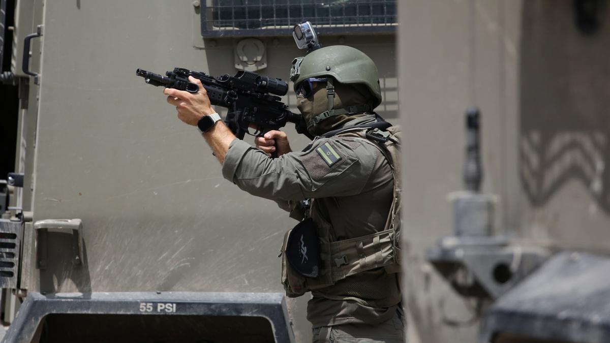 Un soldado israelí apunta a manifestantes en la localidad cisjordana de Nablus.