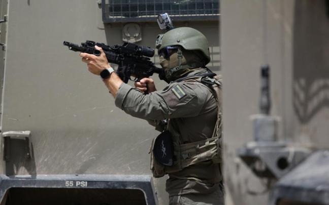 Un soldado israelí apunta a manifestantes en la localidad cisjordana de Nablus.
