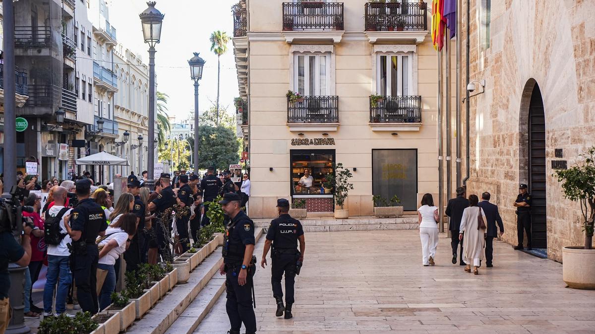 Varias personas con pancartas, durante una concentración para pedir la dimisión de Mazón, frente a Les Corts Valencianes.
