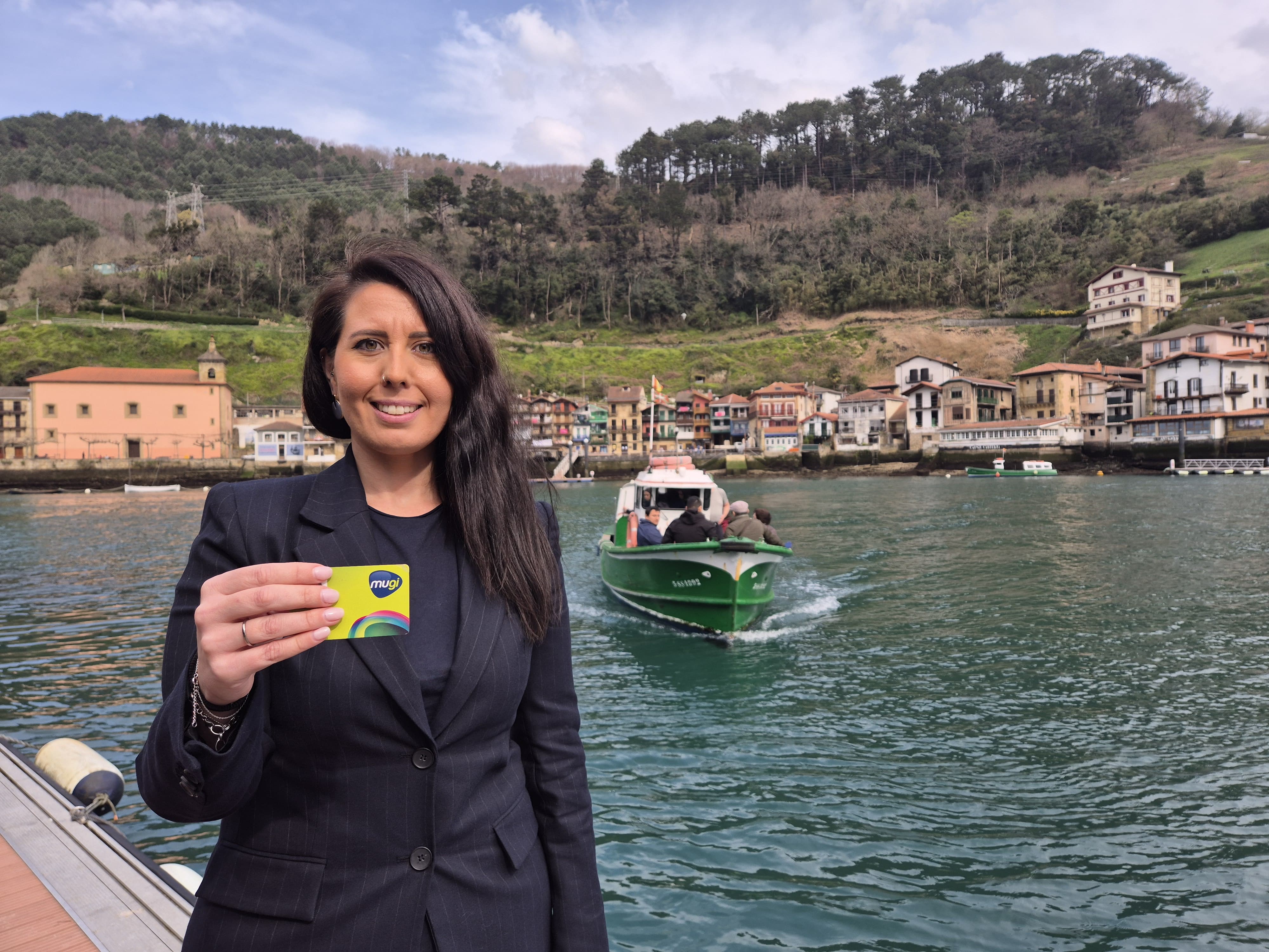 Azahara Domínguez muestra la tarjeta MUGI junto a la motora de Pasaia