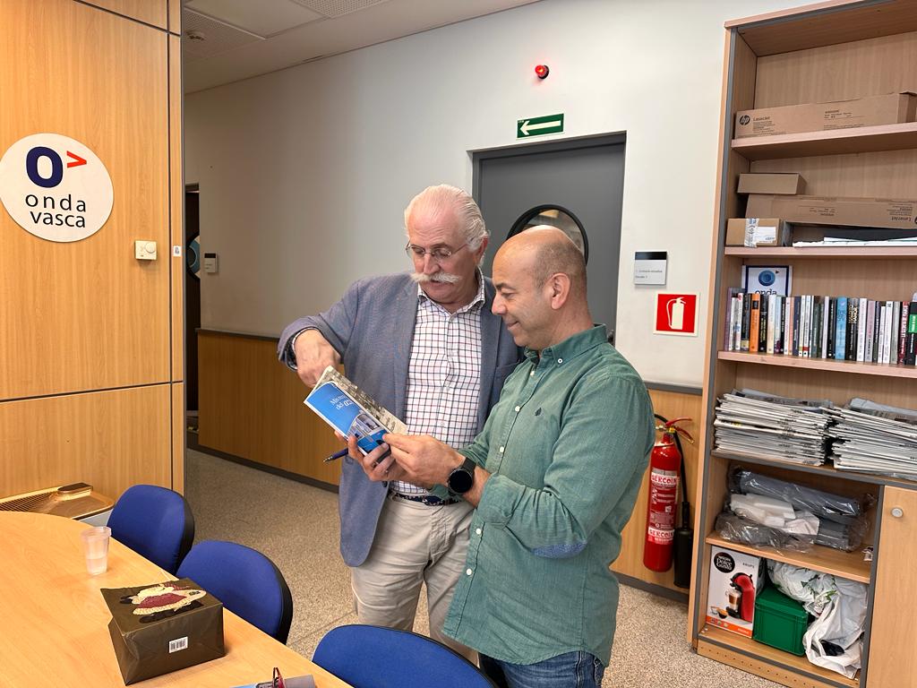 Kepa Elejoste ojea un ejemplar del libro del Azulito junto a Kike Alonso | ONDA VASCA