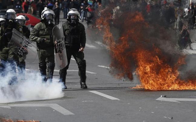 Varios policías esquivan un cóctel molotov durante la protesta. Varios policías esquivan un cóctel molotov durante la protesta.