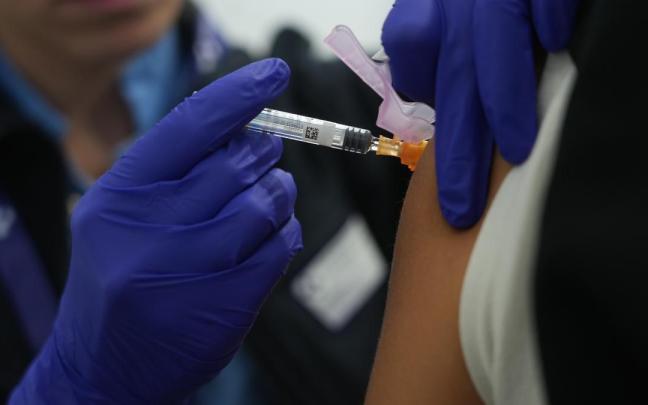 Profesional sanitaria poniendo una vacuna.