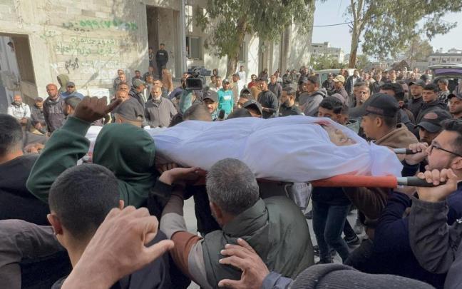 El cuerpo de uno de los civiles muertos en un ataque aéreo de Israel es transportado durante un funeral en Gaza.
