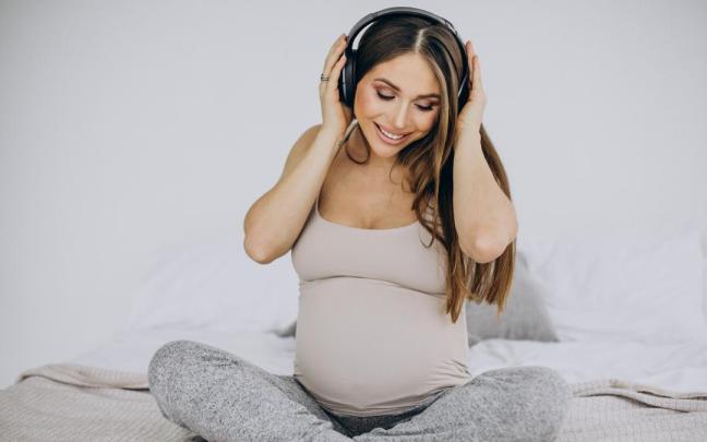 Una mujer embarazada escucha música.