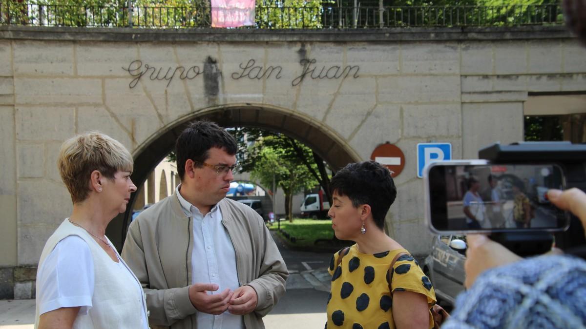 Las concejalas Amaia Ceciaga y Agurne Juldain, y el portavoz Ander Garay en el arco de entrada al Grupo San Juan.