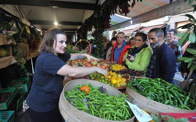 Una mujer atiende a los clientes en un puesto de frutas y hortalizas en la feria del Último Lunes de Octubre, en Gernika. / Jose Mari Martinez Bubu Una mujer atiende a los clientes en un puesto de frutas y hortalizas en la feria del Último Lunes de Octubre, en Gernika.