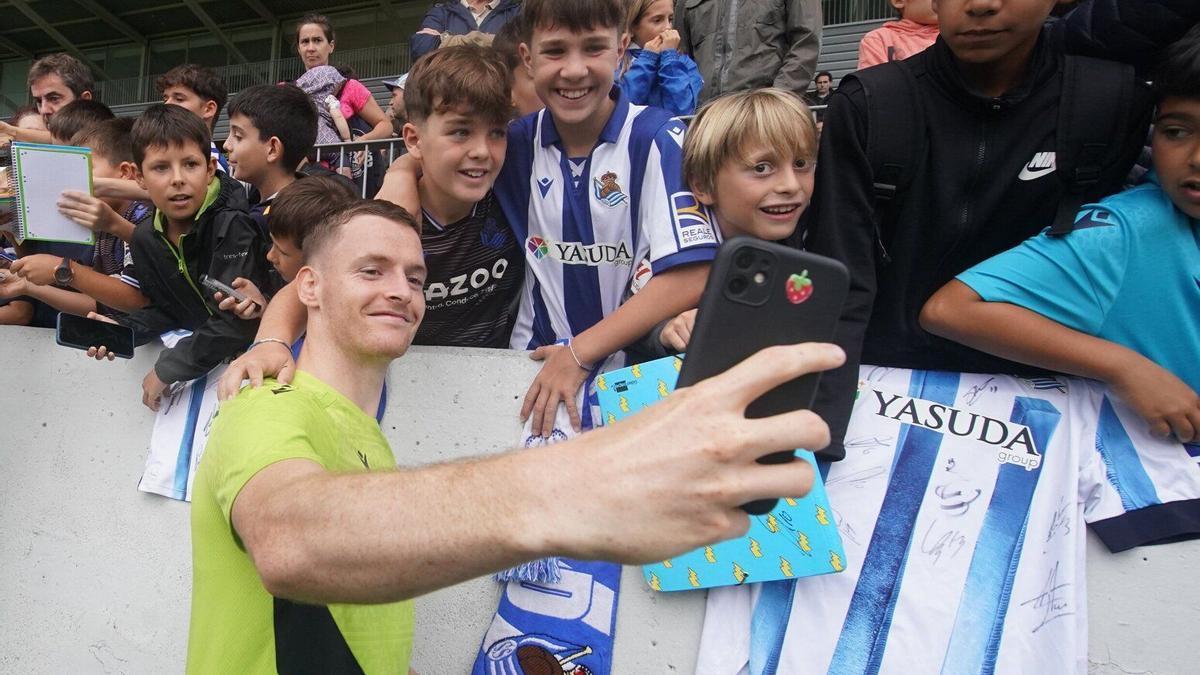 Sergio Gómez se hace un selfie con varios jóvenes realzales, en un entrenamiento en Zubieta. / RUBEN PLAZA