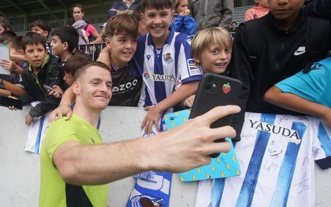 Sergio Gómez se hace un selfie con varios jóvenes realzales, en un entrenamiento en Zubieta. / RUBEN PLAZA