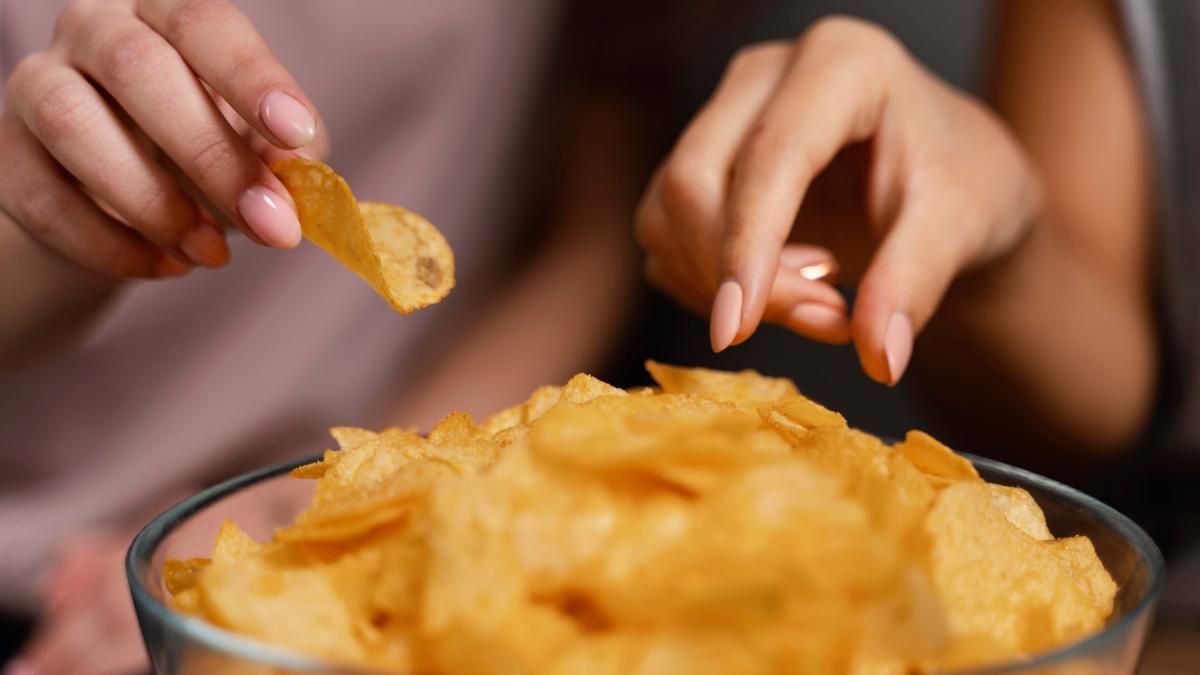 Dos personas disfrutando de un bol de patatas fritas.