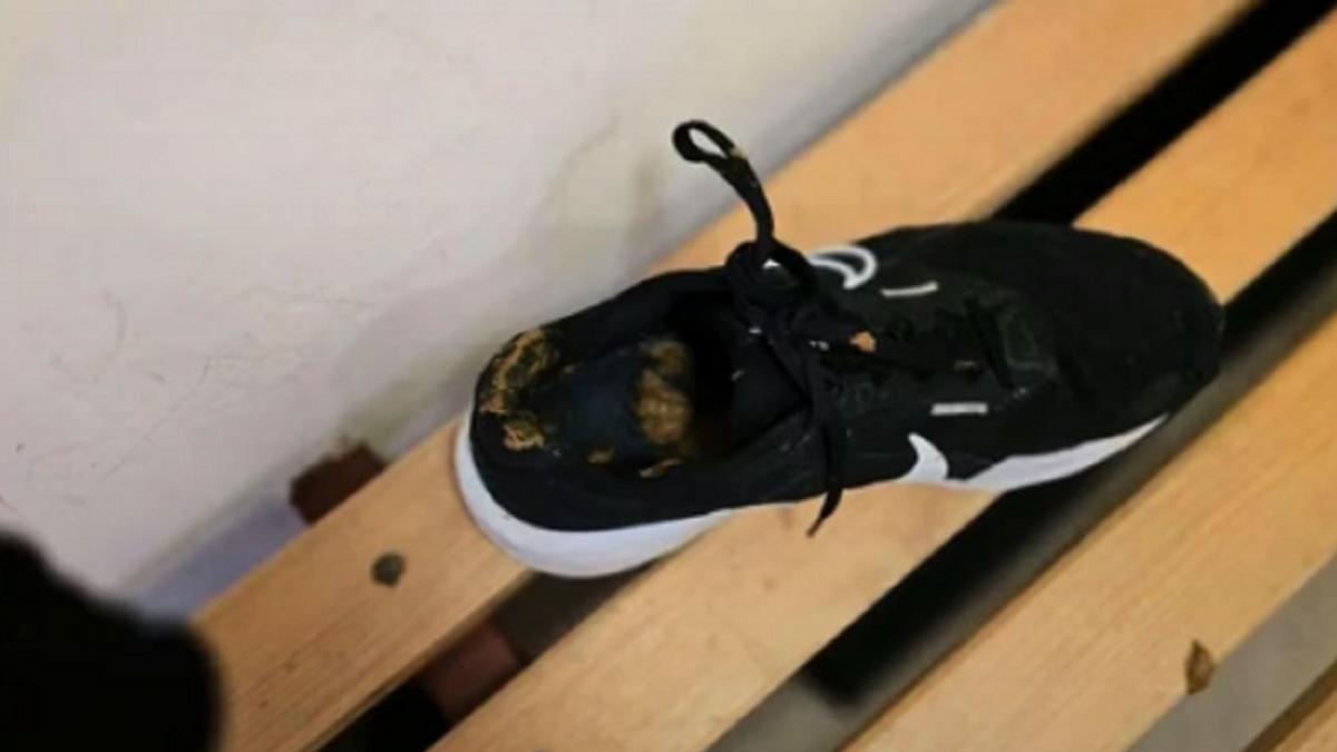 La zapatilla, en el vestuario con las heces en su interior.