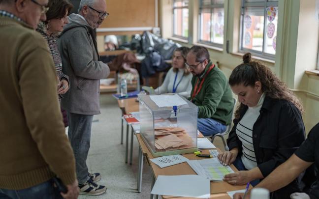 Varias personas votan en un colegio electoral en Extremadura.