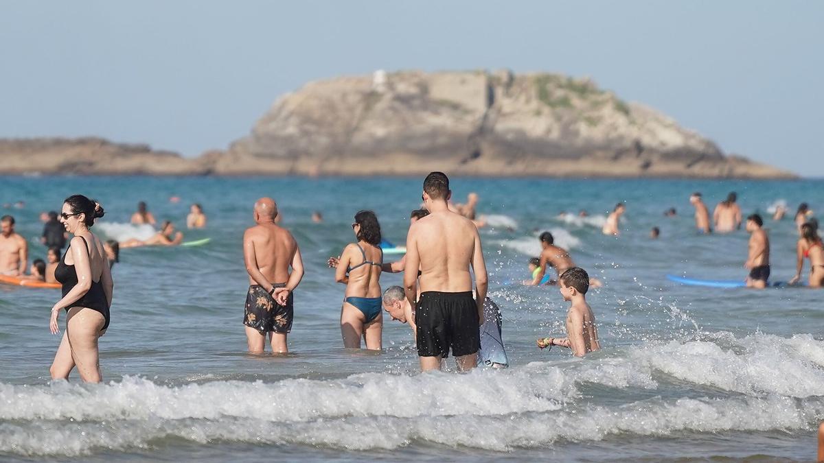 Personas bañándose en la playa de Zarautz.