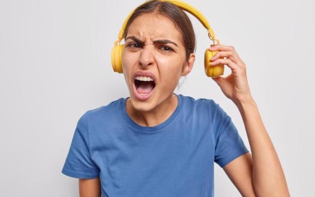 Una joven escucha música a todo volumen en sus auriculares.